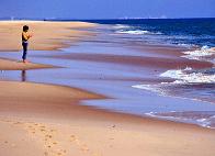 Junger Mann einsam in der Weite des Strandes der Ilha de Tavira